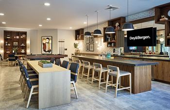 A kitchen with a large island and a bar with chairs